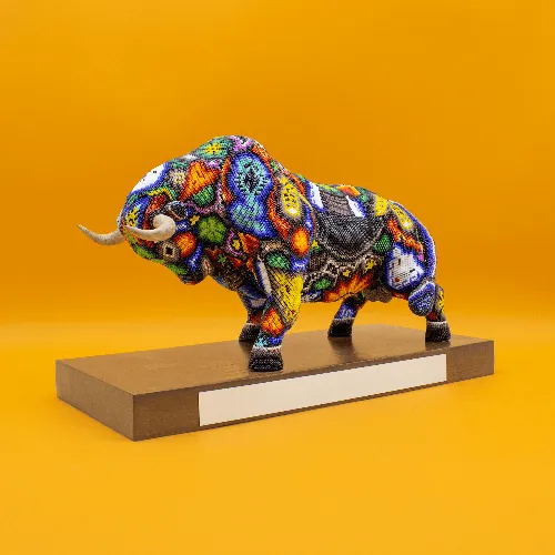 Escultura de Toro embistiendo en base colorido a
