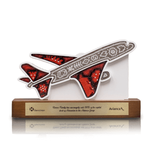 Trofeo con forma de avi´n enchaquirado sobre una base de madera y placa de metal