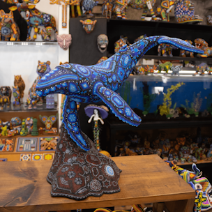 Blue humpback whale sculpture on a brown base covered with beads