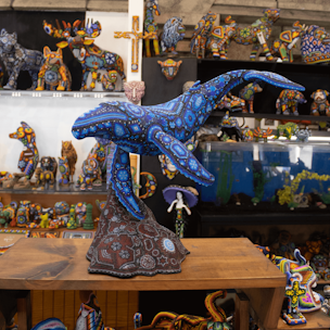 Blue humpback whale sculpture on a brown base covered with beads