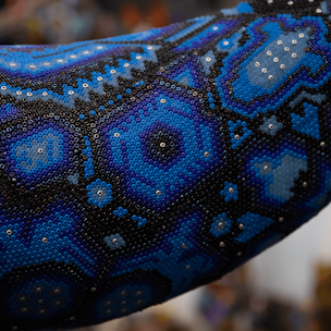 Blue humpback whale sculpture on a brown base covered with beads